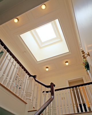 A skylight illuminates the second-floor central hall, around which the master suite, two bedrooms, a bathroom, an additional bedroom suite and a laundry area are organized. 